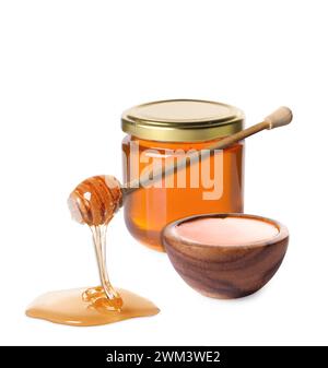 Natural honey dripping from dipper. Jar full of honey and bowl on white background Stock Photo