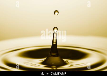 Splash of golden oily liquid with drop as background, closeup Stock Photo