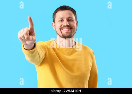 Handsome man using virtual screen on blue background Stock Photo