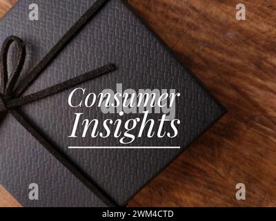 Top view gift box with text Consumer Insight on wooden background. Stock Photo