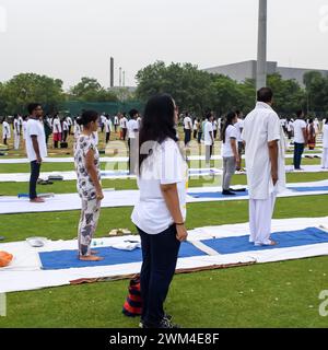 New Delhi, India, June 21, 2023 - Group Yoga exercise session for people at Yamuna Sports Complex in Delhi on International Yoga Day, Big group of adu Stock Photo