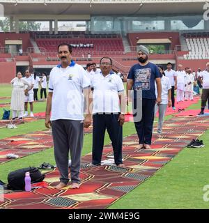 New Delhi, India, June 21, 2023 - Group Yoga exercise session for people at Yamuna Sports Complex in Delhi on International Yoga Day, Big group of adu Stock Photo