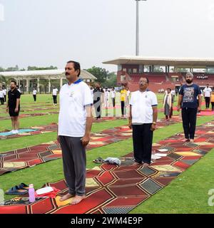 New Delhi, India, June 21, 2023 - Group Yoga exercise session for people at Yamuna Sports Complex in Delhi on International Yoga Day, Big group of adu Stock Photo