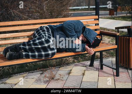 homeless elderly old man lies sleeping on a park bench in autumn Stock ...