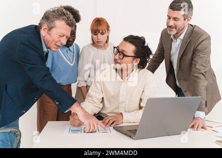 Diverse team collaborating on app design in office - Conceptual discussion with UI mockups - Focused group brainstorming session. Stock Photo