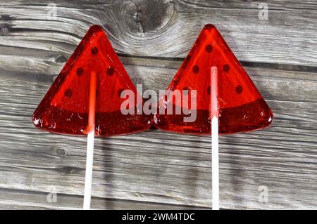 Watermelon flavored lollipop, a type of sugar candy usually consisting of hard candy mounted on a stick and intended for sucking or licking, lolly, su Stock Photo