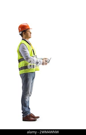 Engineer in a safety vest holding a drone remote controller isolated on white background Stock Photo