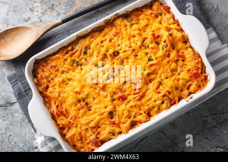King Ranch Chicken Casserole is a Southern Texas staple dish close-up in a baking dish on a marble table. Horizontal top view from above Stock Photo