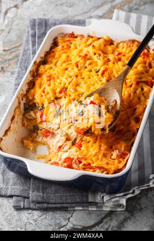 King Ranch chicken casserole is a tender chicken, creamy sauce, tortilla chips and plenty of cheese close-up in a baking dish on a marble table. Verti Stock Photo