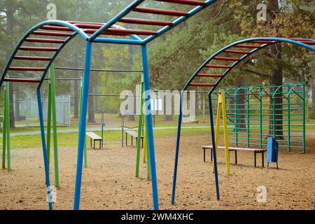 Playground with multi-colored sports elements in the autumn misty forest Stock Photo