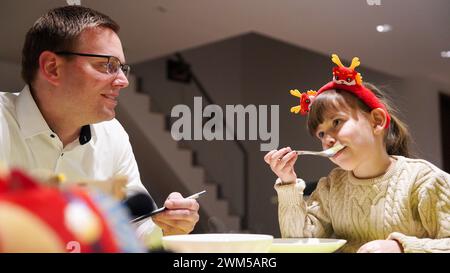 (240224) -- CHANGCHUN, Feb. 24, 2024 (Xinhua) -- Sascha Schuerrer (L) and Julia eat tangyuan, also called glutinous rice dumplings, at home in Changchun, northeast China's Jilin Province, Feb. 23, 2024. German engineers Sascha Schuerrer and his wife Johanna Garzon-Schuerrer, together with their daughter Julia, spend their first Lantern Festival, the 15th day of the first month of the Chinese lunar calendar, which falls on Feb. 24 this year, in Changchun, northeast China's Jilin Province. In order to strengthen the cooperation between China and Germany in the automobile industry, more than 20 Stock Photo