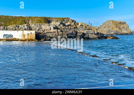 Tarlair Open Air Swimming Pools Macduff Scotland white buildings and the barrier between the pool and the incoming sea at high tide Stock Photo
