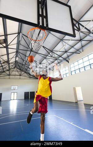 African American man scores during a basketball game in an indoor court with copy space Stock Photo