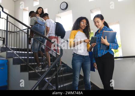 Diverse students gather in a high school stairwell Stock Photo