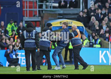 London, UK. 24th Feb, 2024. London, February 24th 2024: Pitch invader Crystal Palace fan resists being escorted off the pitch during the Premier League match between Crystal Palace and Burnley at Selhurst Park on February 24, 2024 in London, England. (Pedro Soares/SPP) Credit: SPP Sport Press Photo. /Alamy Live News Stock Photo