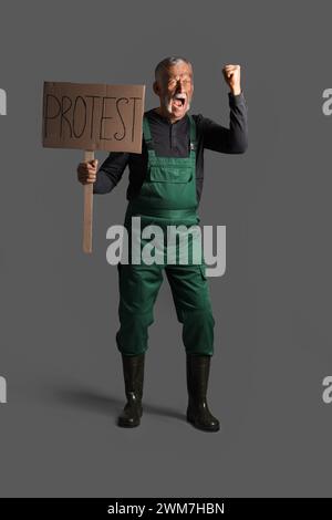 Protesting miner man with placard on dark background Stock Photo