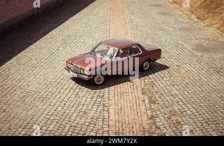 Brown classic Mercedes-Benz W123 coupe from 1970s. Three quarter view from above of brown old car Stock Photo