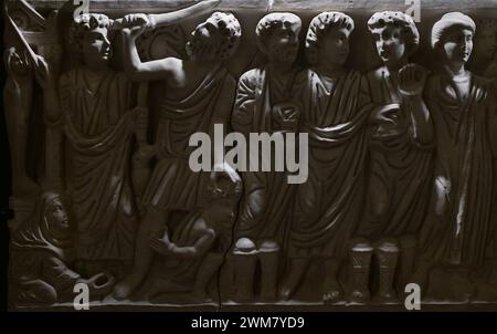 Replica of the sarcophagus of Layos, detail. The original Paleo-Christian sarcophagus was found in Layos, province of Toledo, and is on display at the Frederic Marès Museum in Barcelona. Decorated in high relief with New and Old Testament scenes. From left to right: Raising of Lazarus, Sacrifice of Abraham, Miracle of Fishing and Loaves (Jesus is shown between St Peter and St Andrew), and figure of the prayerful or deceased person. Museum of Visigoth Councils and Culture. Toledo, Castile-La Mancha, Spain. Stock Photo