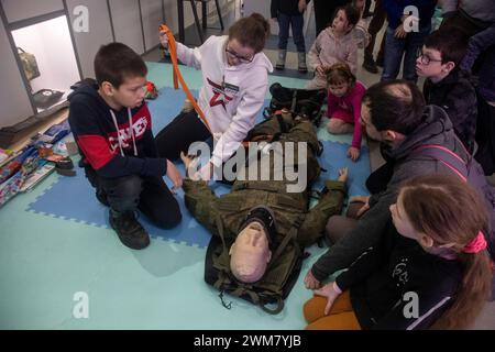 Moscow, Russia. 23rd of February, 2024. People take part in a first aid training while touring the Russian Defence Ministry pavilion at Russia Expo, an exhibition designed to demonstrate Russia's main achievements in culture and technology, at the All-Russia Exhibition Centre (VDNH) in Moscow, Russia Stock Photo