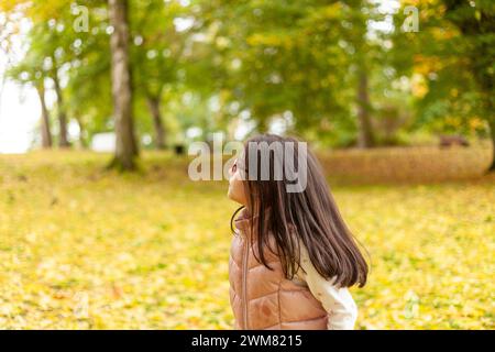 Young woman in the autumn park. Back view. Close-up. Stock Photo