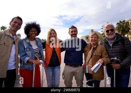 Group portrait of multiethnic happy mature friends looking at the camera, doing tourism in Europe. Stock Photo