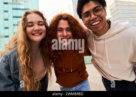 Group of student friends having fun outdoors looking at camera smiling. Stock Photo