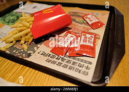 French fries container and ketchup packets on a tray with a liner in Chinese; McDonald's in Taipei, Taiwan; American fast food in Asia; globalization. Stock Photo