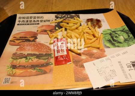 French fries, ketchup packet, and receipt on a tray with a liner in Chinese; McDonald's in Taipei, Taiwan; American fast food in Asia; globalization. Stock Photo