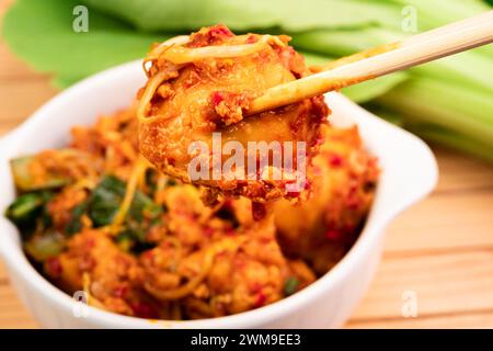 Fried dumplings in a white bowl. Made from wet dumplings that are sauteed with mustard greens, bean sprouts and spicy seasonings Stock Photo