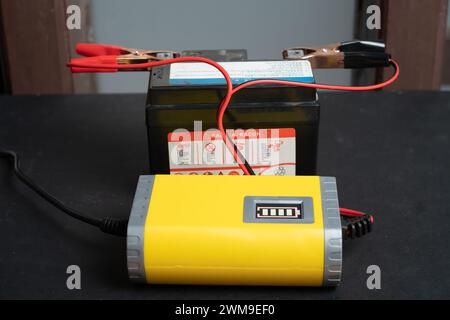 Charging motorcycle battery, battery maintenance and repair concept Stock Photo