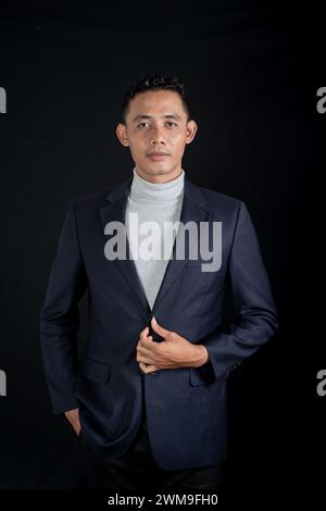 Portrait of handsome elegant man in black suit on black background. Studio mode portrait Stock Photo
