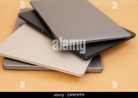 Different modern laptops on brown background, closeup Stock Photo