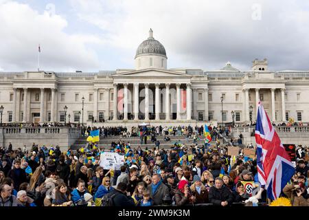 London, UK. 24th Feb, 2024. Protesters gather at Trafalgar Sqaure during the demonstration. Ukrainians and their supporters gathered at Marble Arch and marched down to Trafalgar Square in London on the 2nd anniversary of the ongoing Russian-Ukrainian War. They are asking the UK Government to supply more arms to Ukraine as the war has now dragged onto the third year. Credit: SOPA Images Limited/Alamy Live News Stock Photo