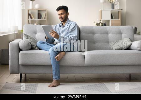 Indian man read e-mail, chatting, browsing wireless internet using tablet Stock Photo