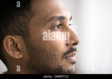 Closeup image of young pensive Indian man looking into distance Stock Photo