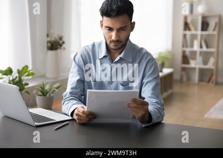 Serious Indian business man working with papers Stock Photo