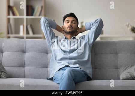 Indian man relaxing at home fell asleep leaned on couch Stock Photo
