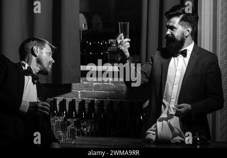 Barmen and customer. Alcohol beverage. Barman at counter. Hipster in bar. Old traditional whiskey drink. Gentlemans beverage. Stock Photo