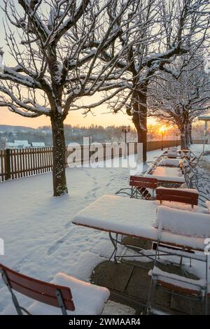 Snow-covered beer garden in winter, sunset, Andechs Monastery, Fuenfseenland, Pfaffenwinkel, Upper Bavaria, Bavaria, Germany Stock Photo