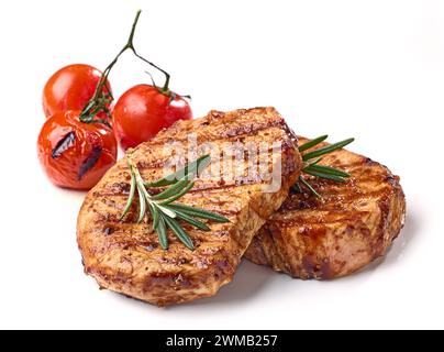 freshly grilled steaks with spices, rosemary and grilled tomatoes isolated on white background Stock Photo