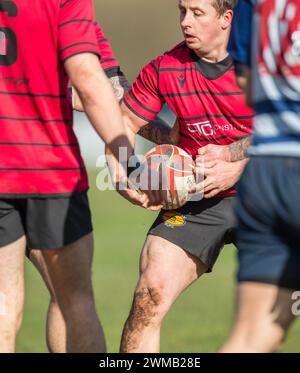 Male amateur rugby union football players playing a game of rugby and