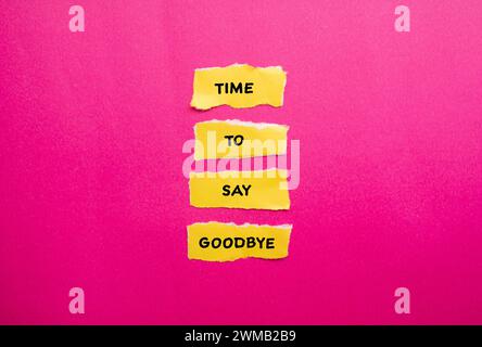 Time to say goodbye words written on yellow torn paper pieces with pink background. Conceptual symbol. Copy space. Stock Photo