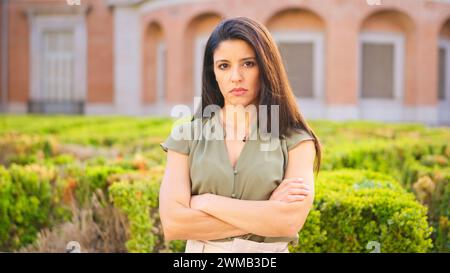 Serious woman looking at the camera while crossing the arms Stock Photo