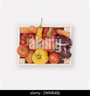 Fresh tasty red and yellow vegetables in wooden crates isolated, healthy eating concept Stock Photo