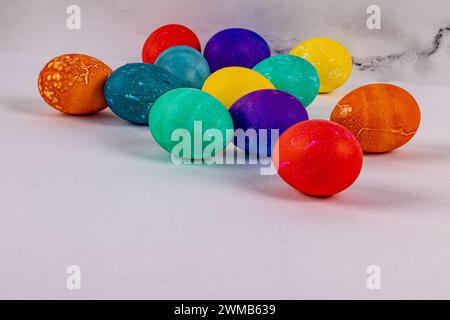 Dozen brightly colored eggs of yellow orange green blue and purple on a marble background with room for copy Stock Photo