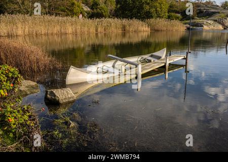 Sunken aluminium canoe in shallow water Stock Photo