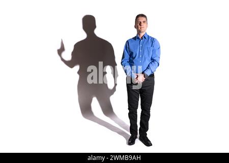 friendly and harmless looking young man whose shadow in the background reveals his evil character Stock Photo