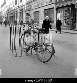 Oradea, Socialist Republic of Romania, approx. 1979. A bicycle rack in a street downtown. Milk cans and bags tied to a bike. Stock Photo