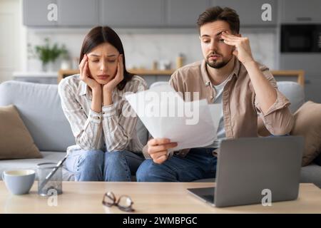 Worried european couple with paperwork and laptop Stock Photo