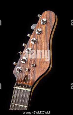 Headstock of an electric guitar with a thin Brazilian rosewood veneer and chrome tuners. Stock Photo